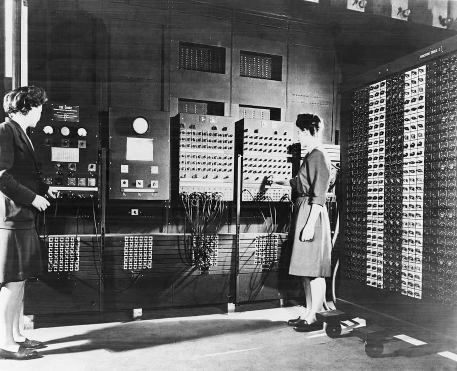 Black and white photograph standing next to electronic boards. 