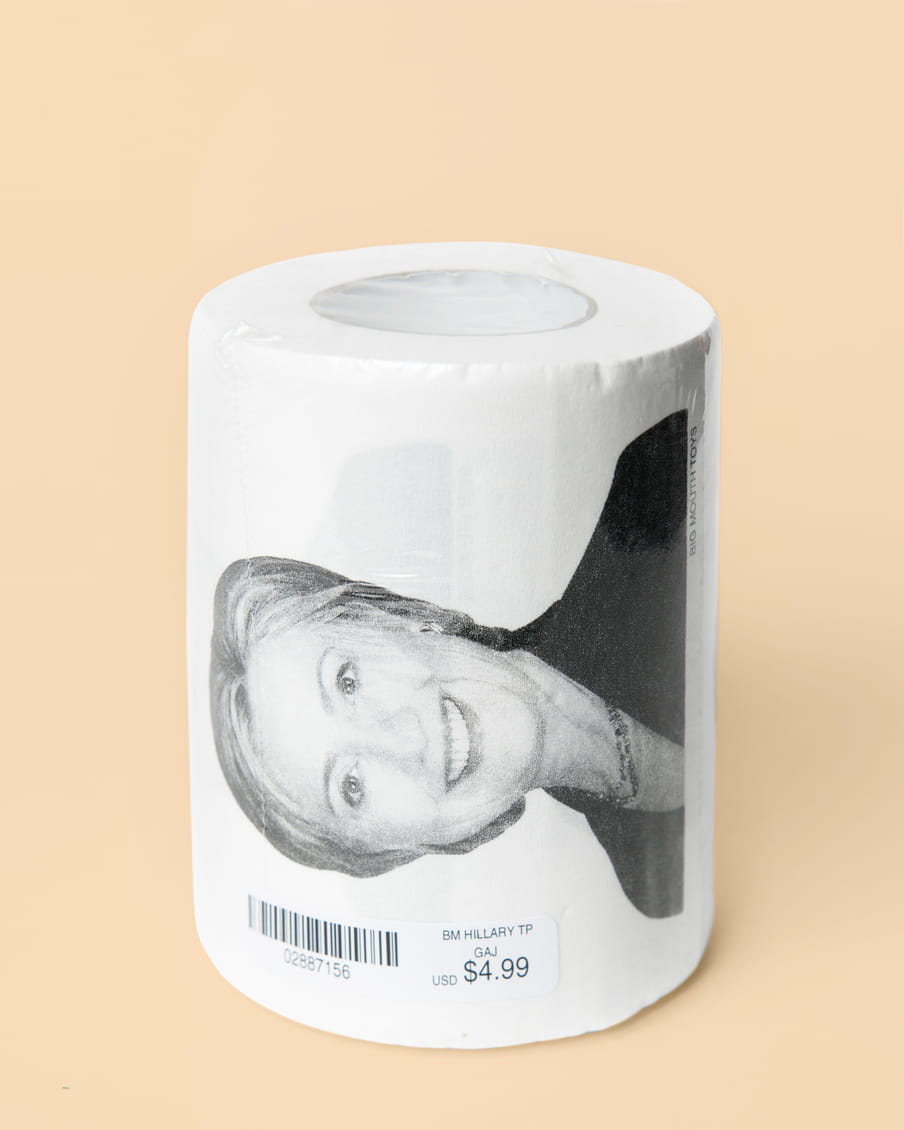 Photo of a roll of toilet paper with a picture of Hillary Clinton on it - on a pink background