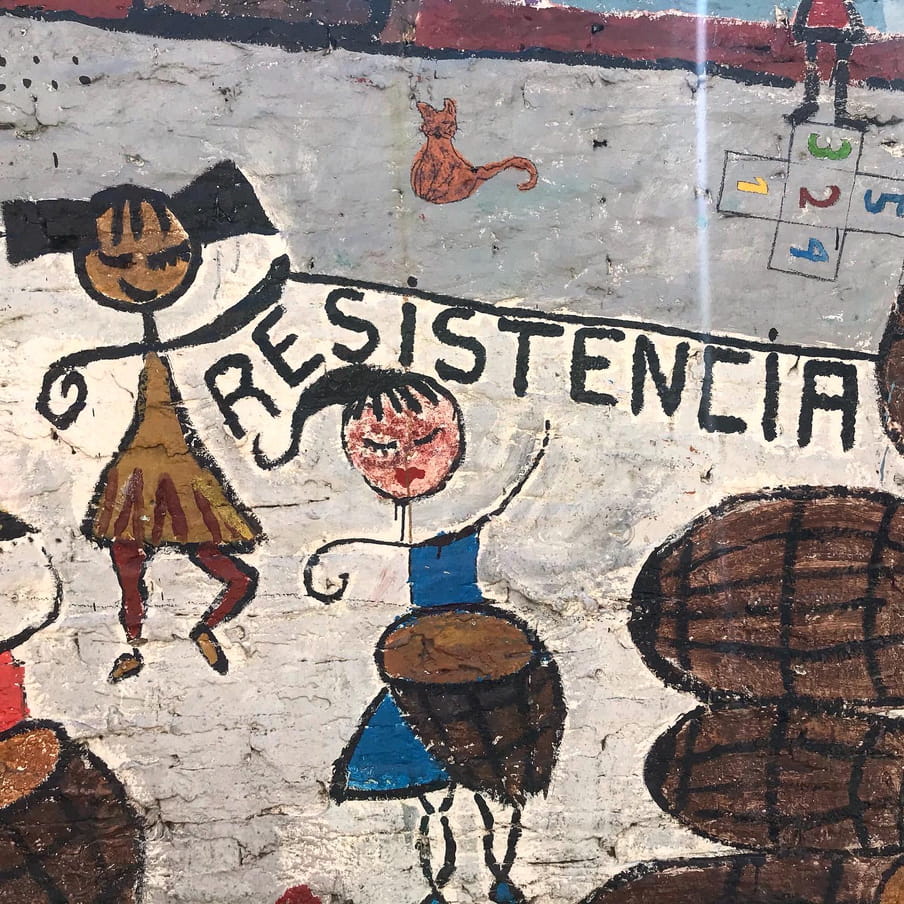 A graffiti of women dancing and beating the drums.