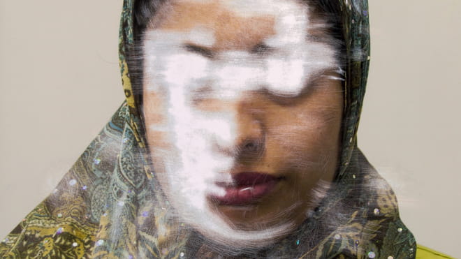 Scratched colour portrait of a woman, in which her face is unrecognisable.