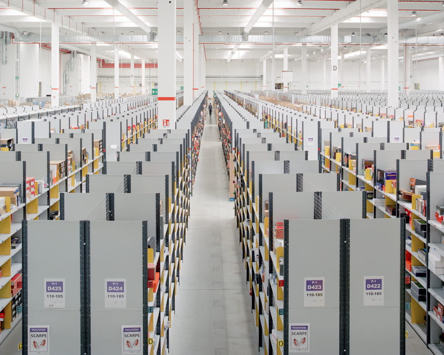 Colour photograph of a warehouse showing shelves. 