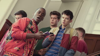 Screenshot from the series Sex Education showing two boys with their boys in their hands. They have a shocked look on their face and are looking at the camera.