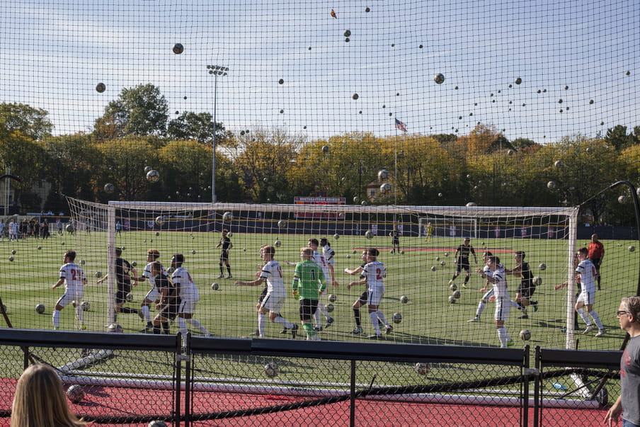 Photo-montage of a soccer field, heavily crowded with men playing.