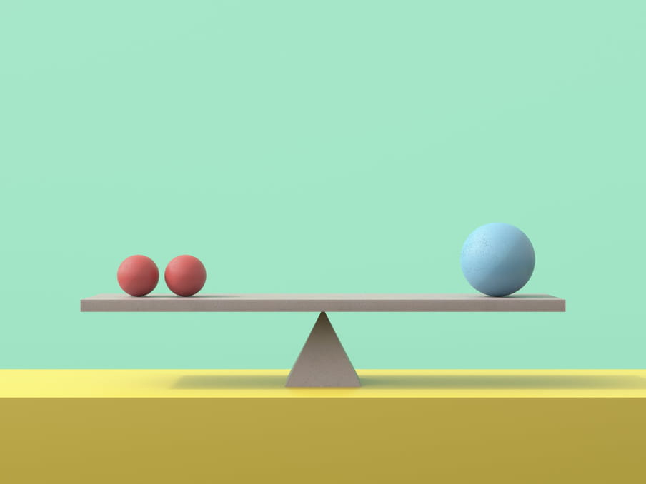 Image against a light green background illustrating a balance, formed of a 3D triangle on a bright yellow shelf, holding a grey plank which has two smaller red balls on one side and one larger blue ball on the other side. The shadow of the plank lies across the yellow shelf below.