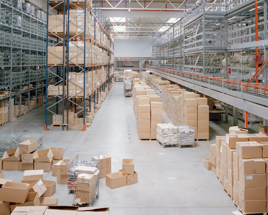 Colour photograph of a warehouse showing shelves and boxes. 