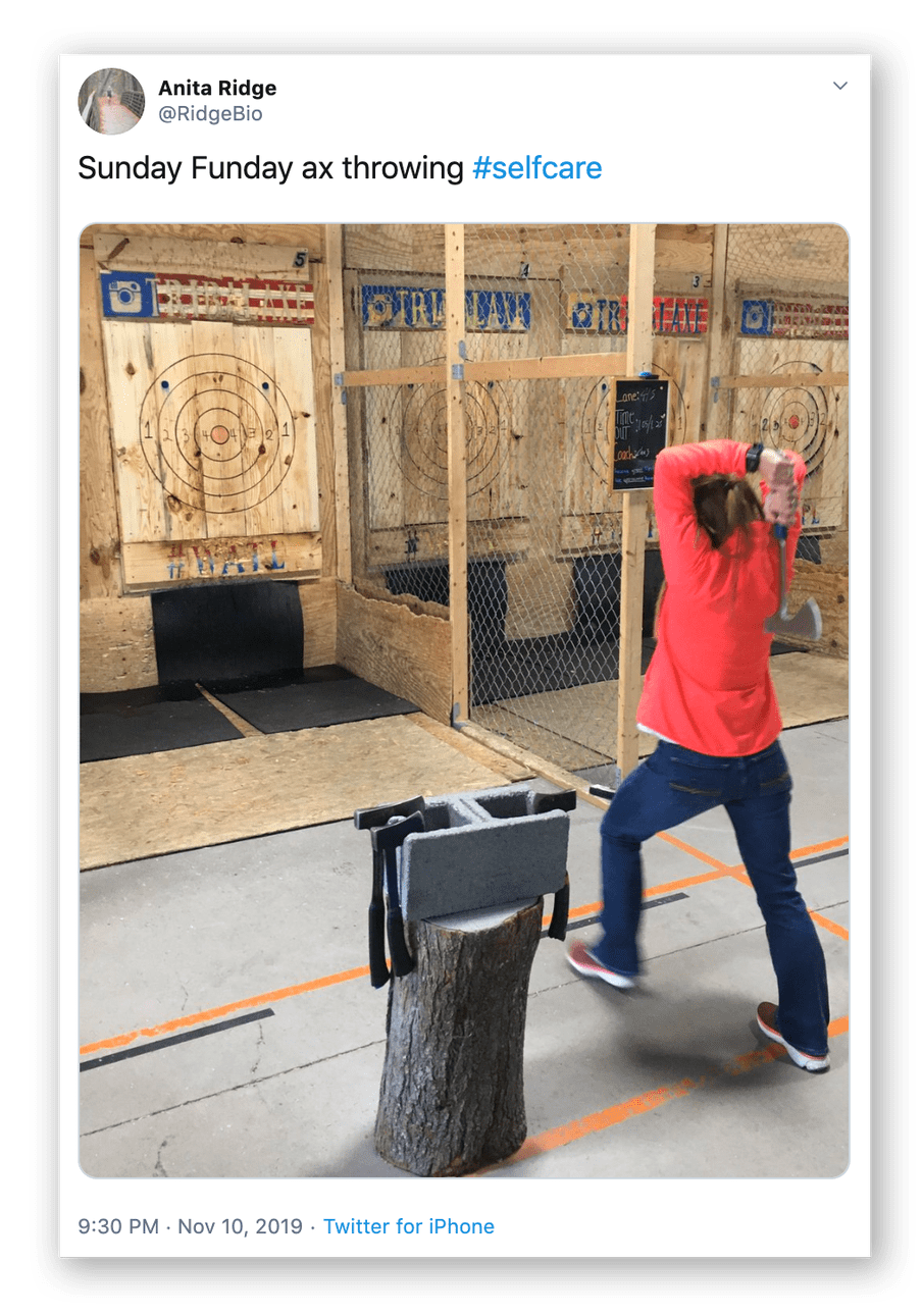 Screenshot of a twitter post by Anita Ridge showing a woman trowing an axe at a wooden board.