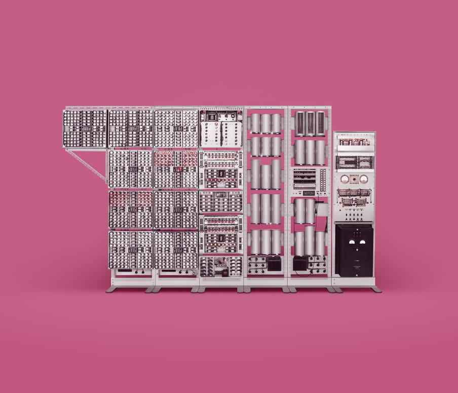 Photo of an old computer against a bright pink background