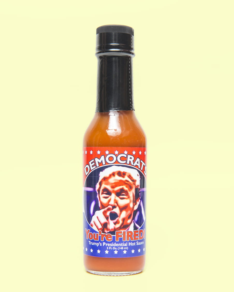 Photo of a bottle of hot sauce stating ‘Democrats, you’re fired’ - on a yellow background