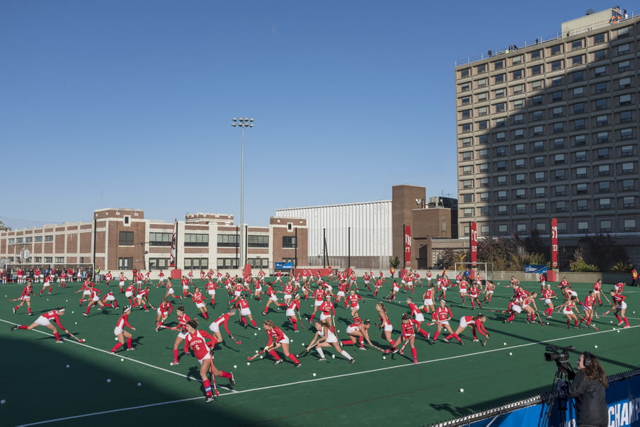 Photo-montage of a field hockey, heavily crowded with women playing.