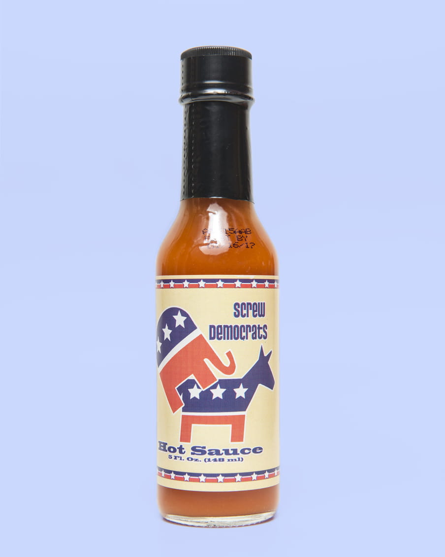 Photo of a bottle of hot sauce stating ‘Screw democrats’ - on a purple background