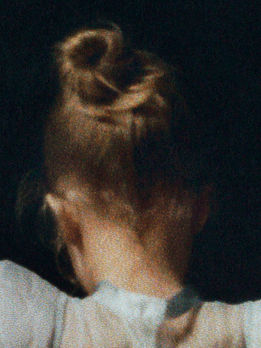 Close up the back off a girls heads, her hair in a bun