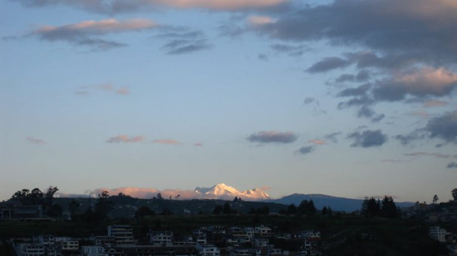 A photograph of the snowy peak of Mount Antisana in the distance.