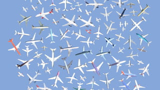 A profusion of planes, some white, others with touches of colours, arranged ob a blue background. 