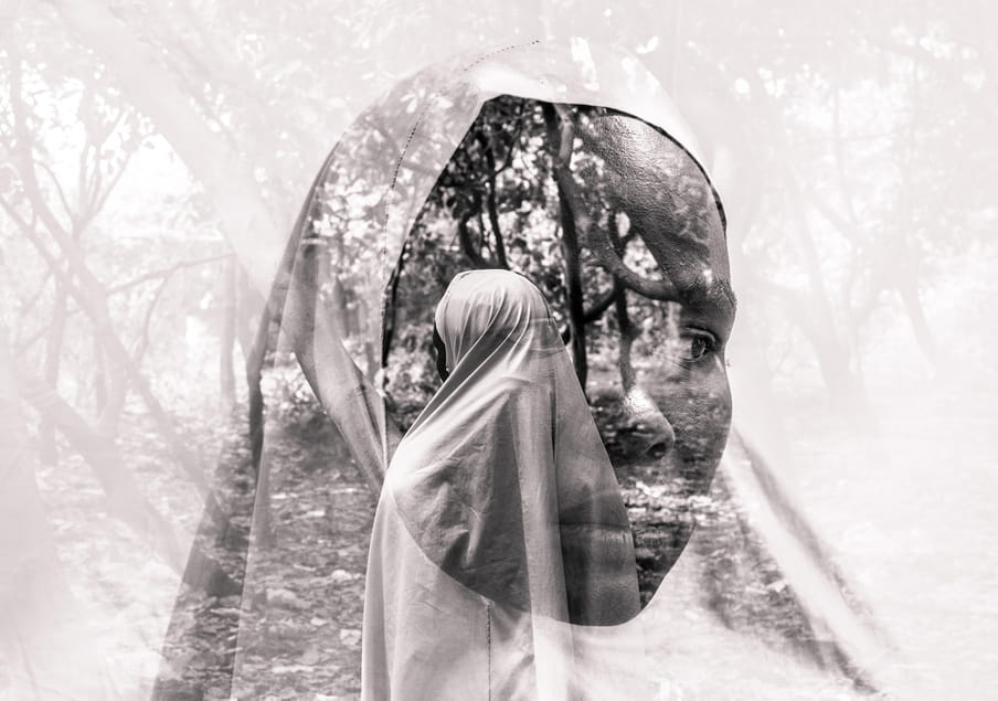 Two superimposed black and white photographs of a face in a white headscarf tied around the face looking to the right; behind this image is a picture of a figure shrouded in a white long abaya standing in what seems to be a forest