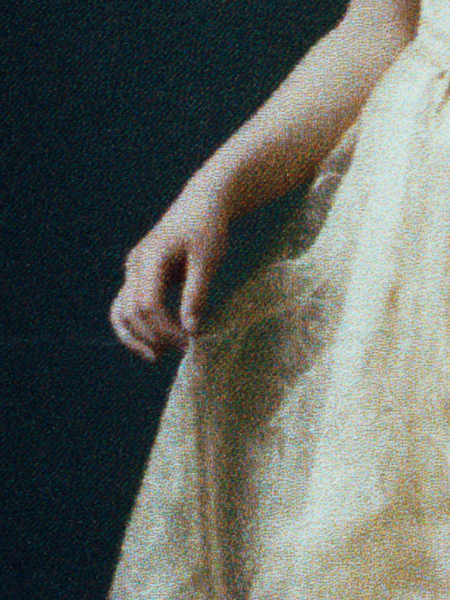 Close up of a girls hand, holding her yellow dress