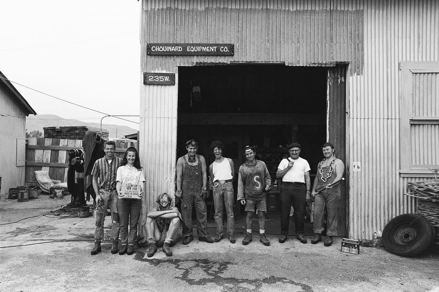 Black and white photo of group of people standing in front of a garage