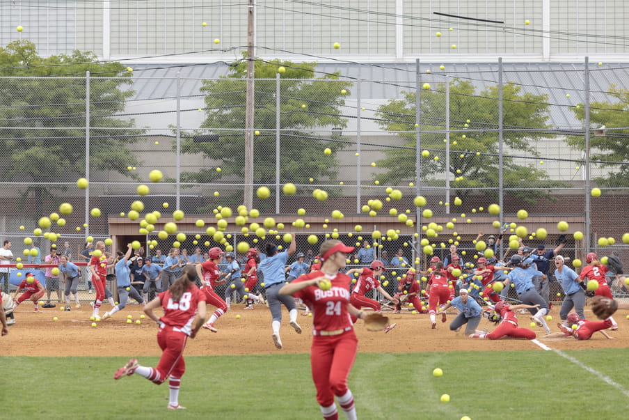 Photo-montage of a softball field, heavily crowded with women playing.