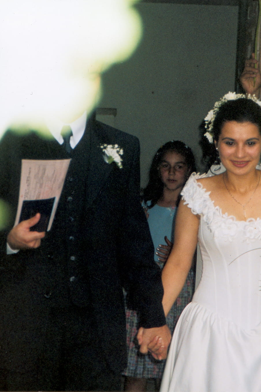 Photo of a groom and bride, a yellow light flare blocking the head of the groom.