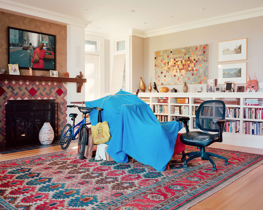 Photo of a living room of a middle or upper class house, with a homeless shelter built from blankets