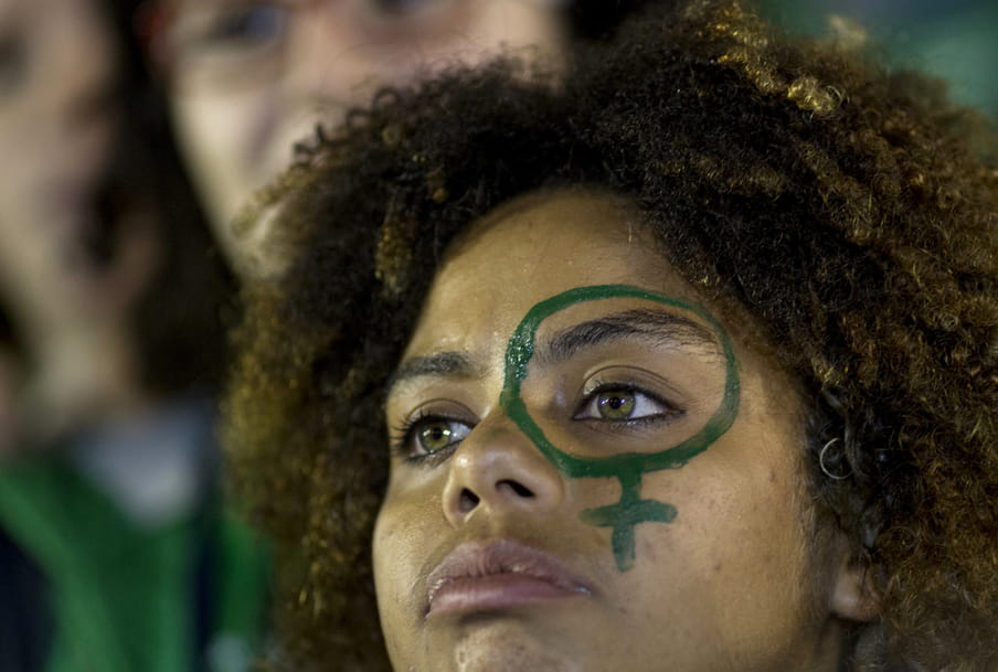 Photo of a girl with dark curly hair and green eyes with a venus sign on her face