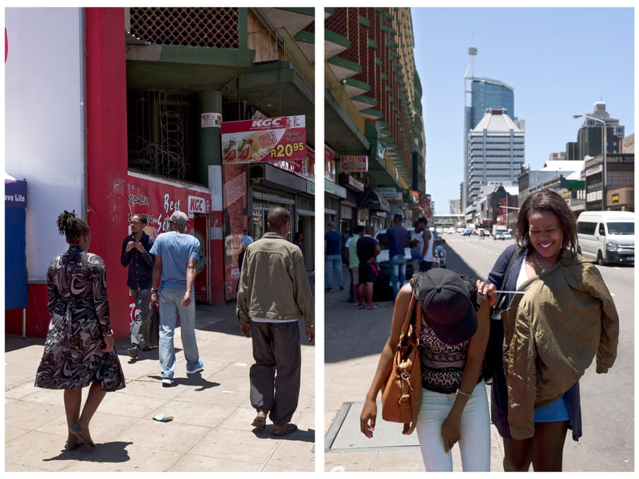 An image of people walking across a street, two women laughing in the front. In the background the sings of a local store called KGC.