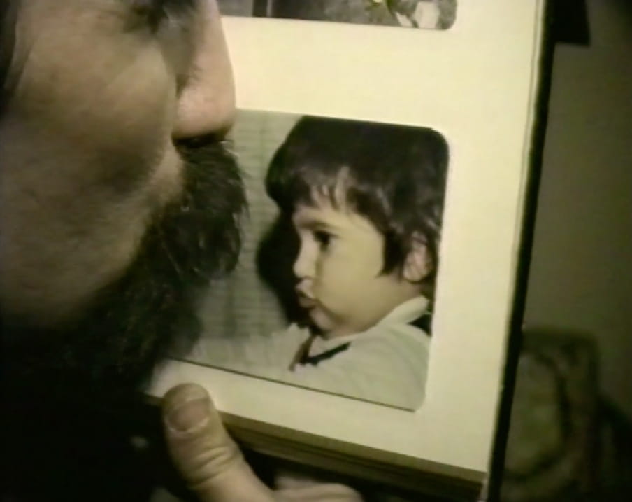 A father kisses a picture frame with the image of Maryam Zaree as a child.