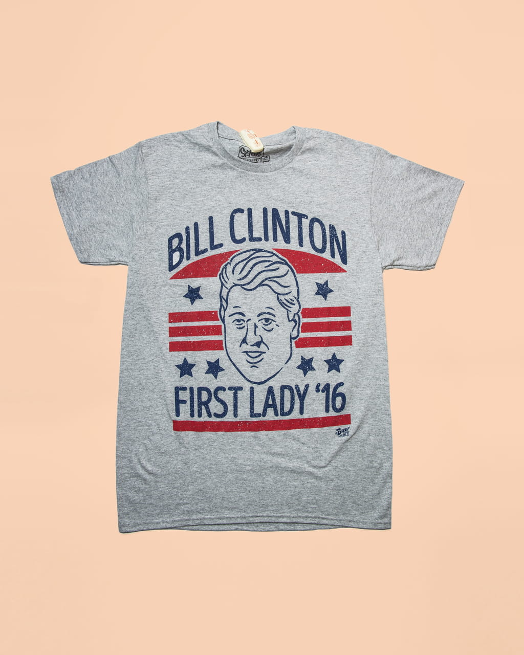 Photo of a grey t-shirt saying ‘Bill Clinton, first lady ‘16’ on a salmon coloured background