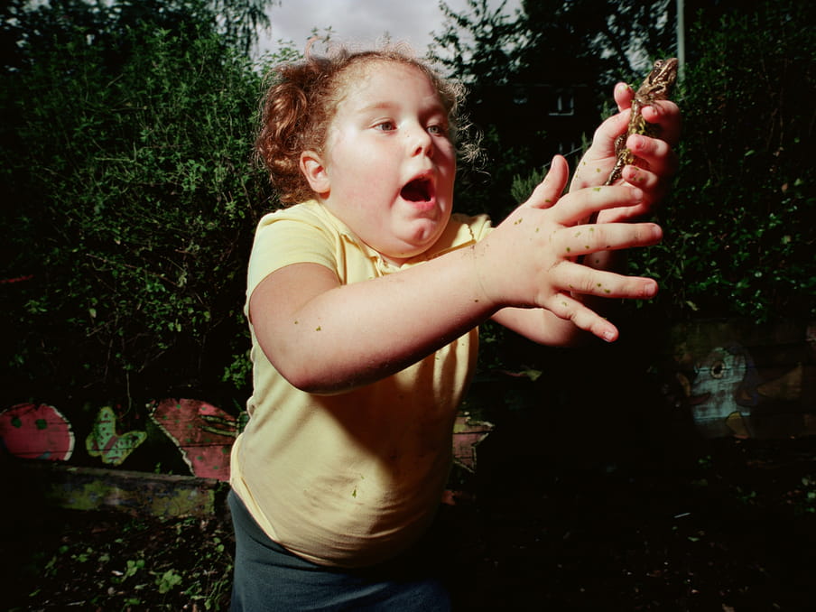 Photo of a kid at the center playing with a frog.