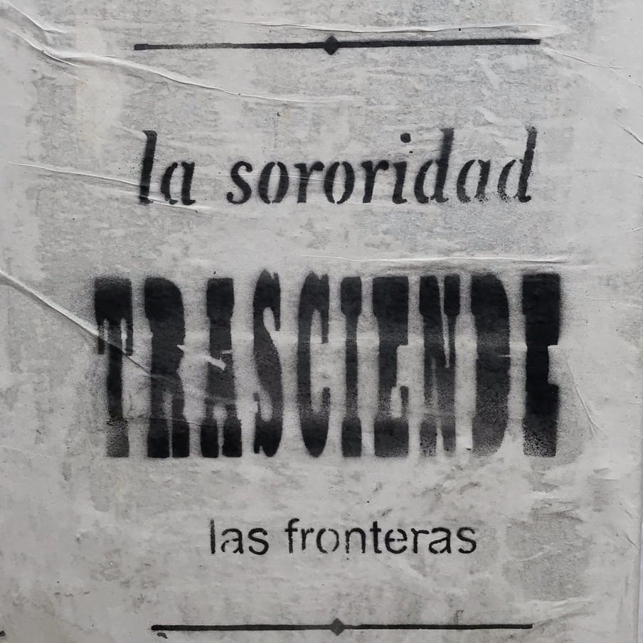 A poster says: La sororidad trasciende las fronteras. This is: Sorority transcends borders in Spanish.