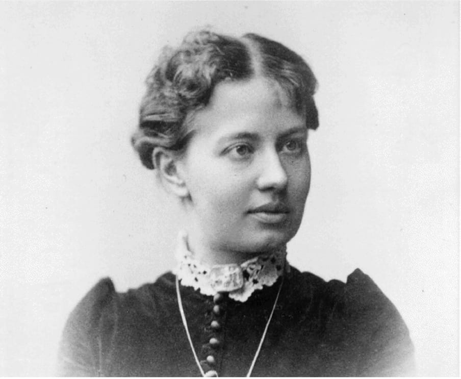 Black and white head and shoulder portrait of a woman looking on the side.