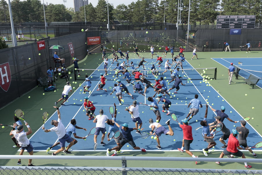 Photo-montage of a blue tennis field, heavily crowded with men playing.