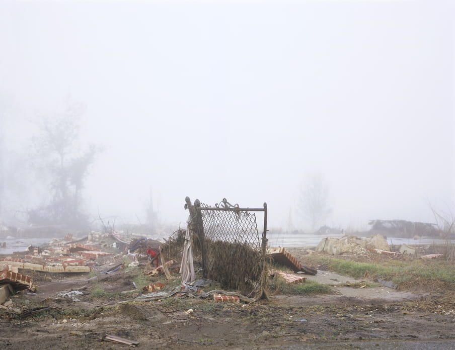 Photo of a place where a house used to be, with only a small fence still standing