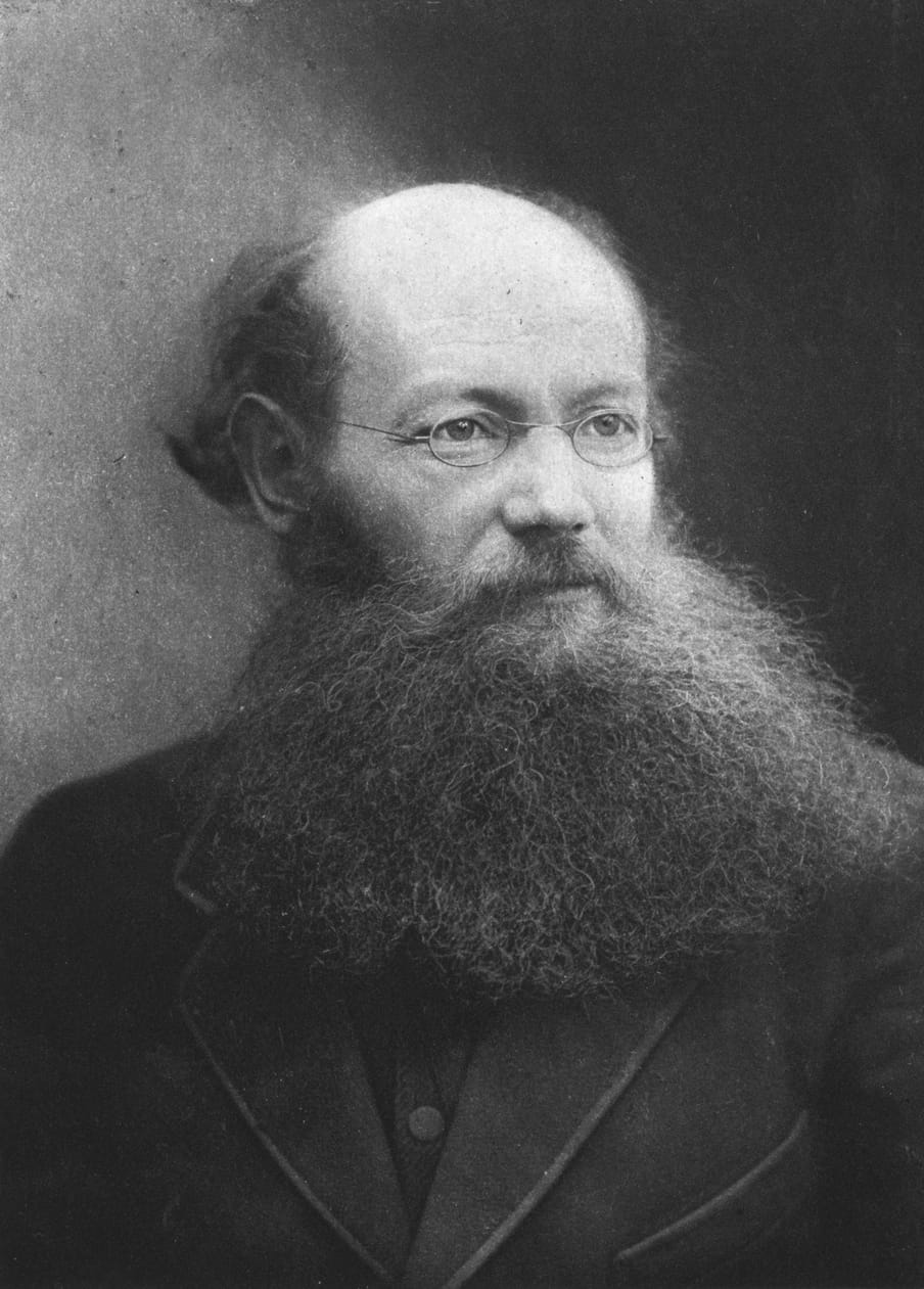 Black and white portrait of a man with glasses and a beard.