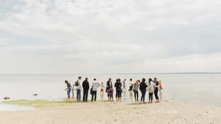 Photo of a group of people standing on a beach