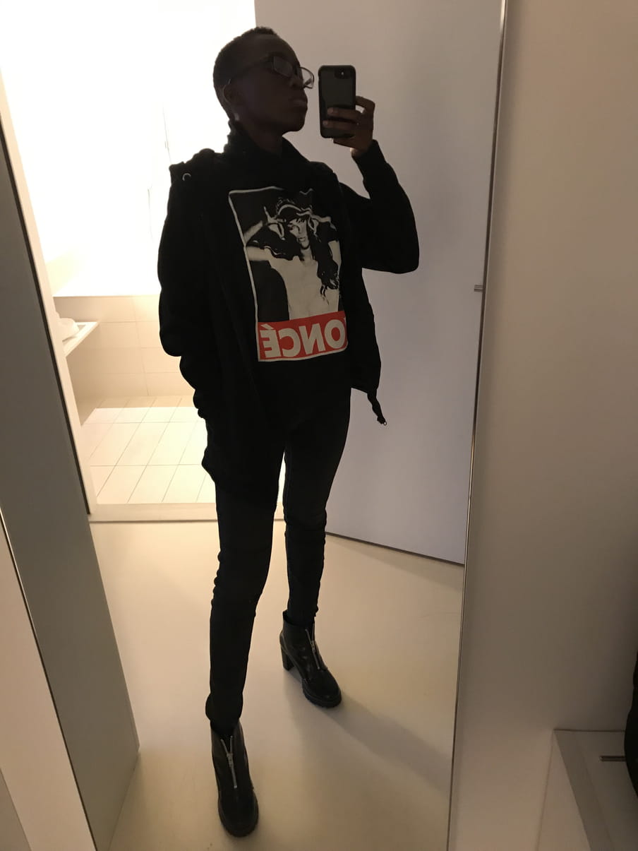 OluTimehin Adegbeye wears a Beyoncé t-shirt in a backlit bathroom