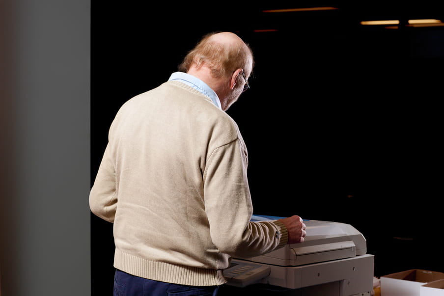 Photo of a man standing in front of a copy machine