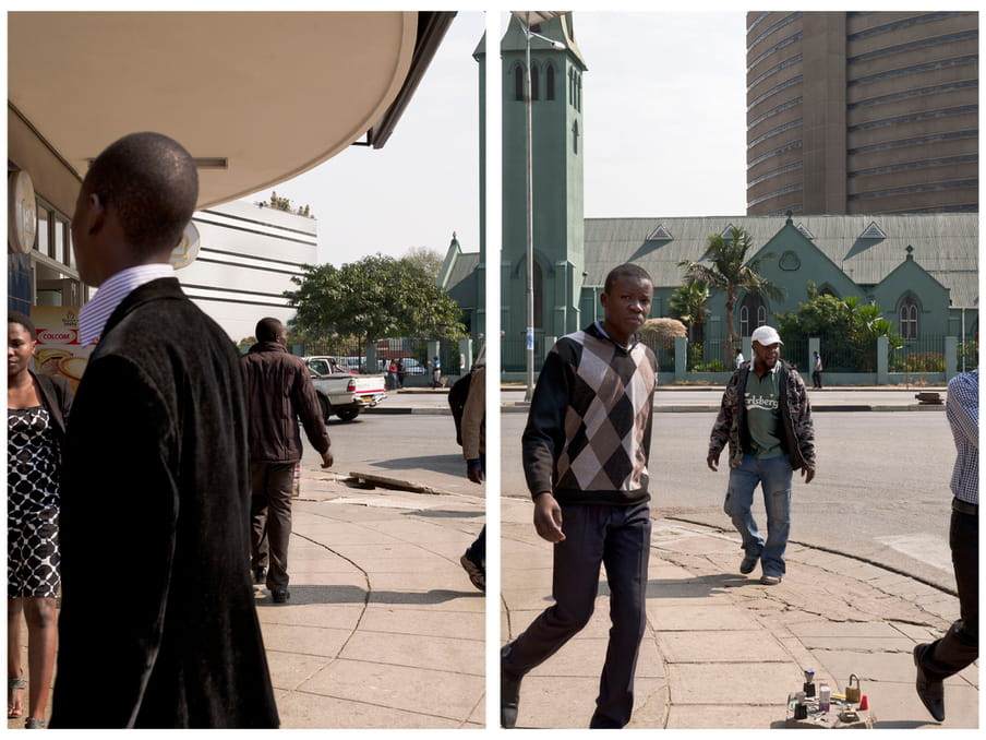 An image of people walking across a street - modern buildings in the background.