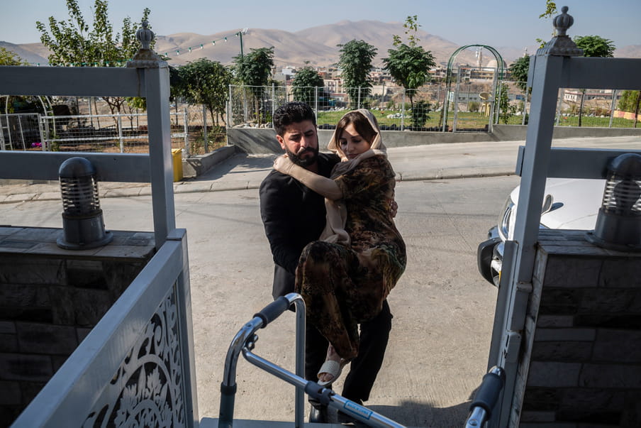 Photograph of a man carrying a woman in his harms