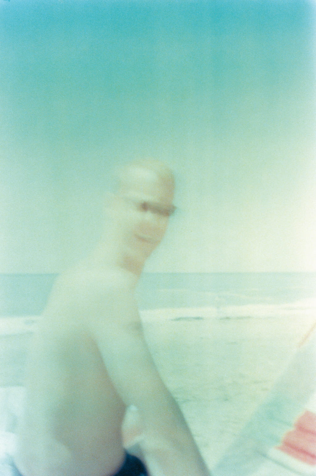 A photo of a man on the beach, he is moving and not in focus.