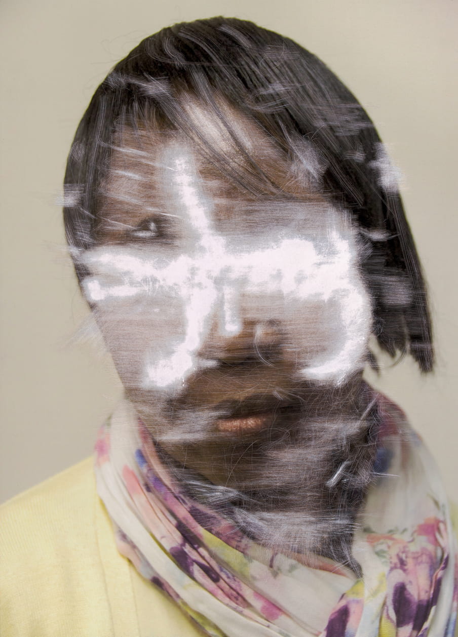 Scratched colour portrait of a woman, in which her face is unrecognisable.