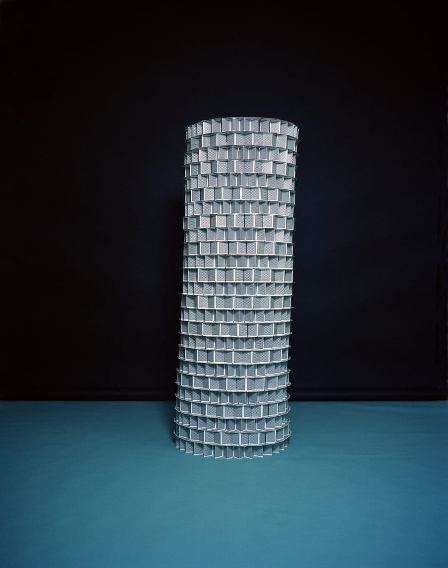 A gigantic tour made of blue and white playing cards shot on a black background and on a sapphire blue carpet floor. 