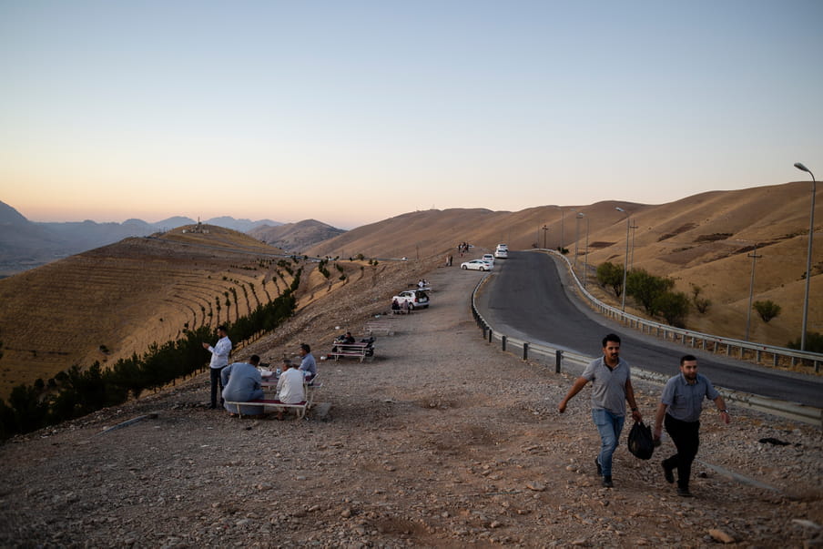 Photograph of a street in a valley with people walking along it