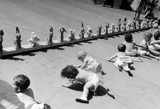 Babies crawling toward a mobile row of stuffed animals during the 1946 Diaper Service Derby. Photo by Cornell Capa / Getty Images