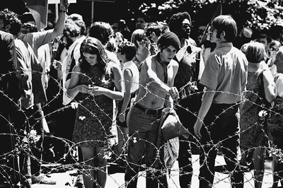 Demonstrators place flowers on a barbed wire fence in People’s Park on the campus of the University of Berkeley, 1969. Photo by David Fenton/Getty Images