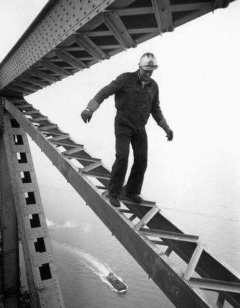 A construction worker balancing on a bridge girder high above San Francisco in California, c. 1955.  Photo by Ernst Haas / Getty Images