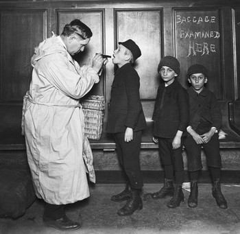 Immigrant children being examined by city health officer upon arrival at the battery from Ellis Island during Typhus Scare. New York, 1911. Photo by Getty