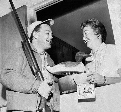 An unsuccessful duck hunter hands his wife a decoy and a cookbook for preparing it. Photo by Underwood Archives / Getty Images 